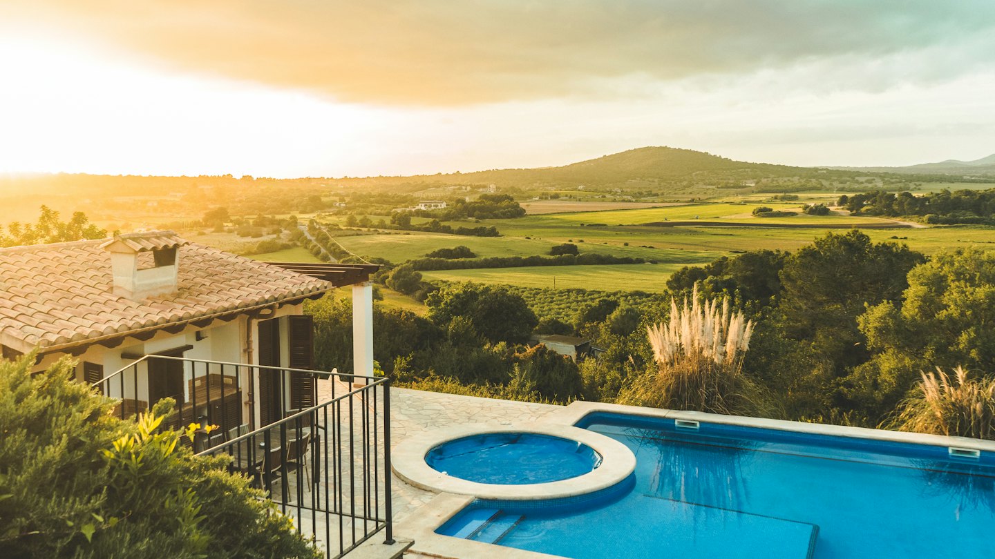 Mediterrane Villa mit Pool und Blick auf ein grünes Tal.